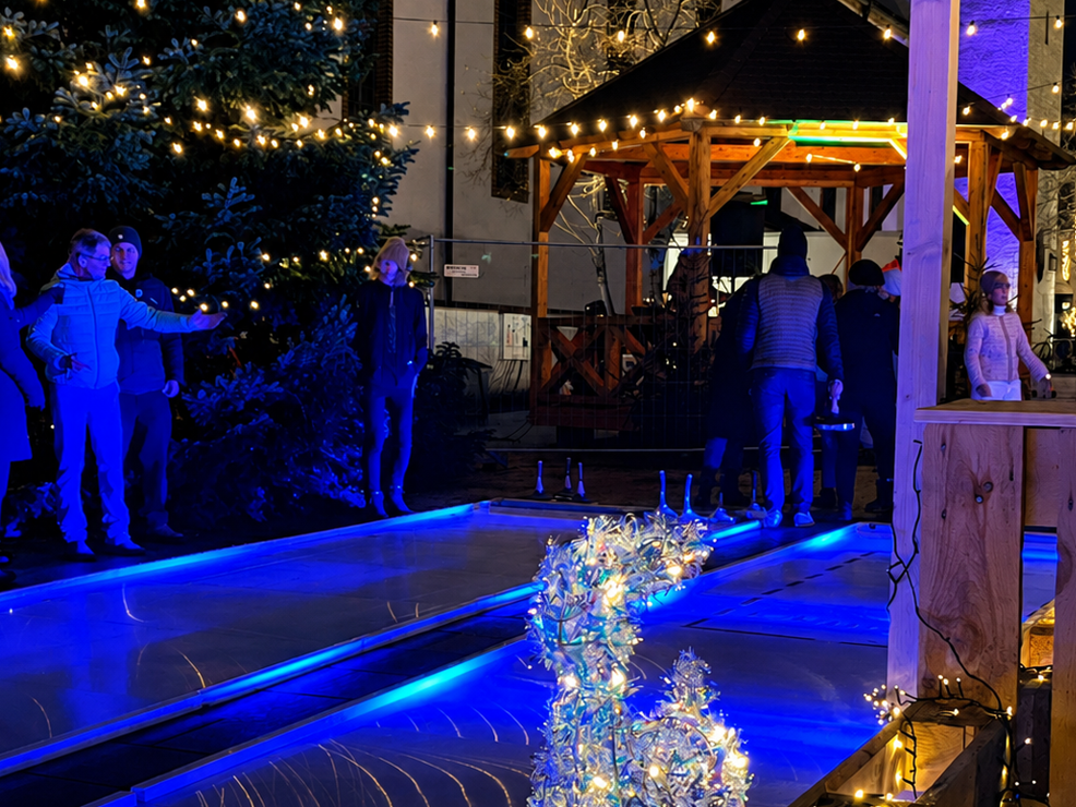 Die Eisstockbahn am Abend ist hell beleuchtet
