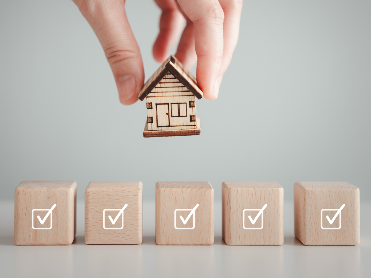 Ein kleines Haus wird auf Bauklötze gesetzt