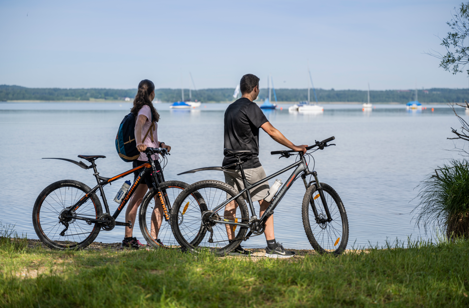 Zwei Radfahrer stehen am Ufer des Sees