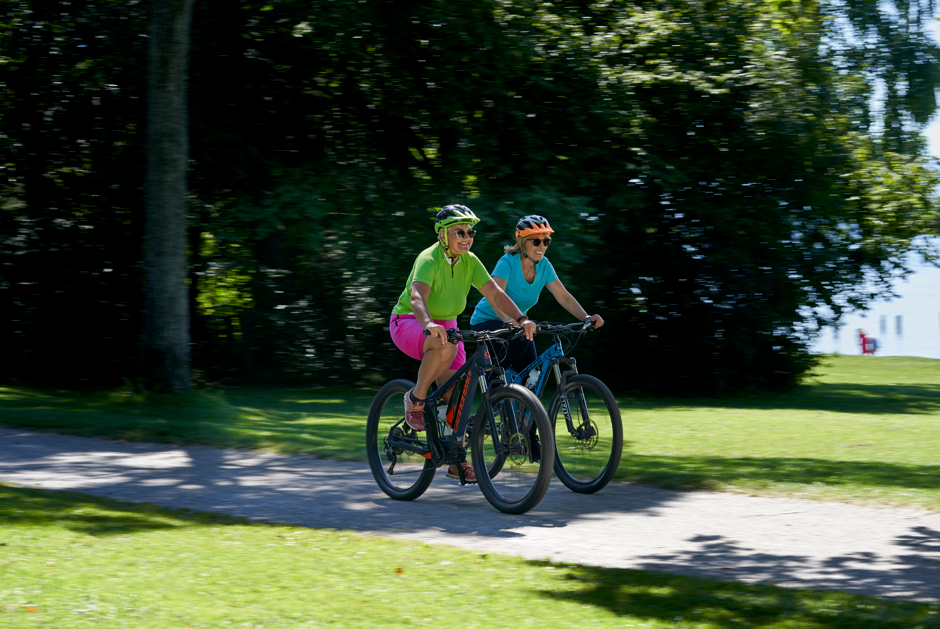 Zwei Frauen radeln am See